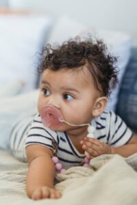 A cute baby sucking on his pacifier. Your writing sucks? No. Many things naturally suck, like this baby, and he ROCKS