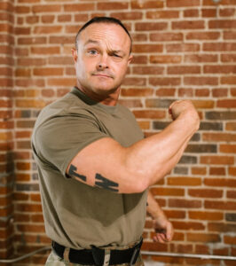 A man posing in an exaggerated stance of victory. Your Writing Sucks? Never, you will be victorious.