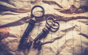 A pair of skeleton keys resting atop a crumpled paper with cursive handwriting. What Should I Write About?